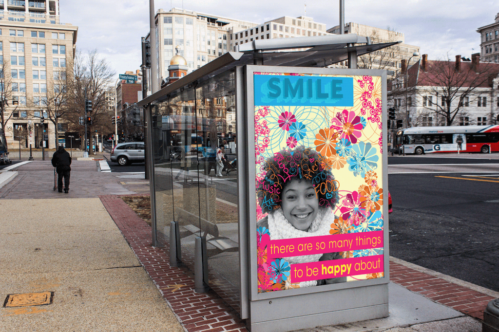 "Positivity" poster mockup on side of bus stop with text saying "Smile. There are so many things to be happy about" accompanied by a woman smiling and doodles, drawings, and hand-drawn text in blue, pink, and orange