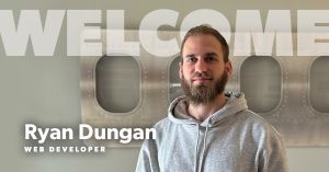 photo of our new hire, Ryan Dungan with the text "welcome" behind him and "Ryan Dungan - Web Developer" in the lower left corner.